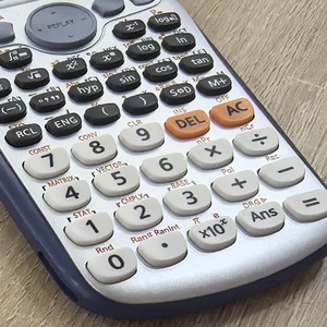 Detailed close-up of scientific calculator keys with advanced functions on silver panel
