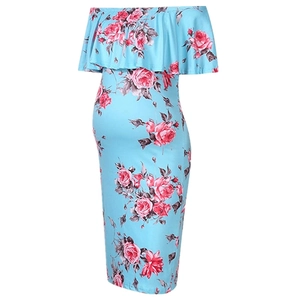 Gros plan d'une robe de maternité épaules dénudées avec fleurs roses sur fond bleu