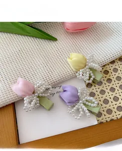 Detail of sweet tulip hair clips with handmade pearl bows in pink, purple and yellow