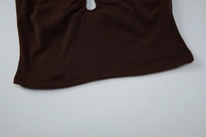 Detailed close-up of dark brown knit fabric with circular cutout and shimmering texture