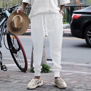 Detail of white men's jogger with cable knit jacquard texture and drawstring waist