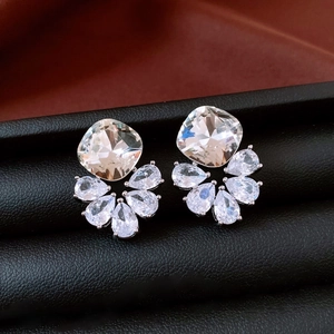 Vue macro de boucles d'oreilles pendantes en argent avec zircone poire sur support en cuir
