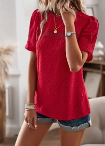 Close-up of red short sleeve top featuring hollow embroidery and a classic round neckline