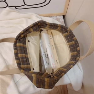 Detail of checkered canvas tote bag interior with beige lining and zipper pocket