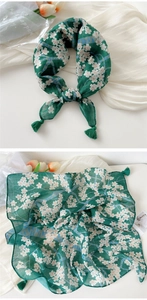 Detail showing green floral cotton scarf with white flowers and matching green tassels