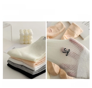 Gros plan de chaussettes en coton tricoté avec broderie noire et maille respirante fine