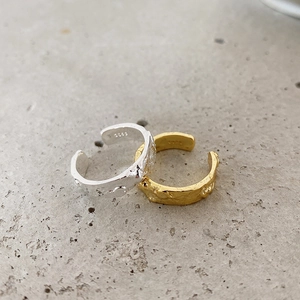Detailed view of irregular hammer texture and S925 hallmark on silver and gold rings