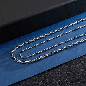 Detailed view of polished silver stainless steel box chain necklace on dark background