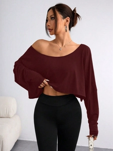 Detail of burgundy off-shoulder long sleeve crop top with soft knitted texture
