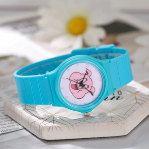 Detail of blue quartz watch featuring a cute cartoon pig dial and pink Arabic numerals