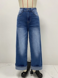 Dettaglio dei jeans a vita alta con gamba larga e risvolti fissi sul fondo del pantalone