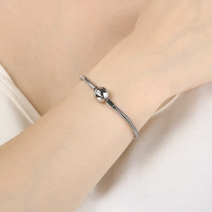 Detail of silver snake bone chain bracelet with polished bead on wrist