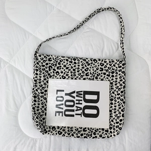 Size comparison showing leopard print canvas tote bag next to an A4 paper sheet