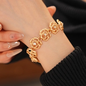 Detailed view of elegant gold hollow flower bracelet with sparkling rhinestones on wrist