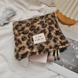 Leopard print plush makeup bag showing interior storage for brushes and skincare