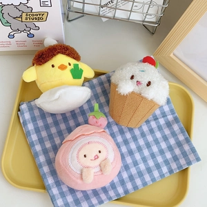 Plush strawberry and cream cheese cake charms on a tray for bags and keychains