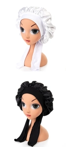 Detailed view of white and black satin hair bonnets with long ties on mannequin