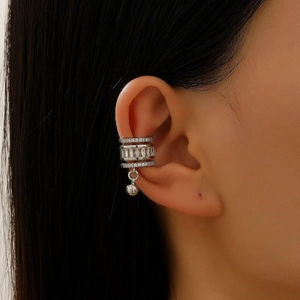 Macro shot of silver ear cuff featuring three rows of cubic zirconia and a beaded charm