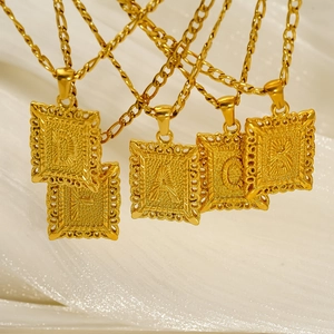 18K gold plated stainless steel hollow letter pendant necklaces on white fabric
