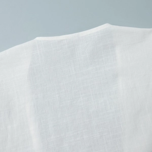 Macro detail of white linen fabric texture and stitching on a round neck collar garment