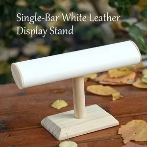 Minimalist single tier jewelry display stand with light wood base and white leather bar