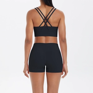 Détail de la brassière sport croisée et du short taille haute dans l'ensemble yoga noir