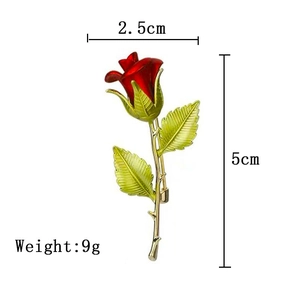 Detail view of red rose brooch with green leaves and dimensions 2.5cm by 5cm