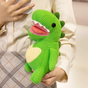 Handmade crochet green dinosaur plush toy with yellow heart detail held by person