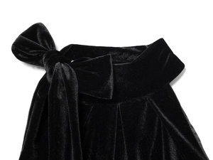 Detail view of the black velvet fabric texture with a large decorative bow design