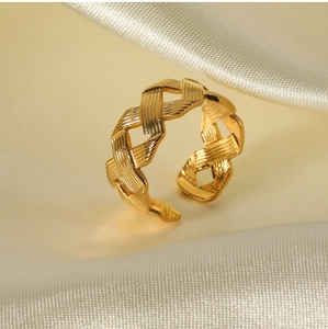 Macro detail of golden woven twist ring texture on elegant beige silk background