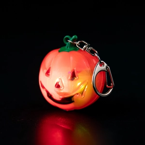 Glowing orange pumpkin keychain with green stem and silver metal clip for Halloween
