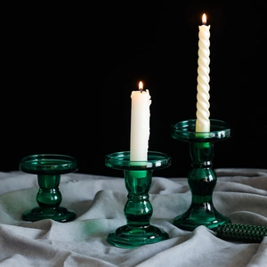 Elegant set of three vintage green glass candle holders on grey velvet fabric