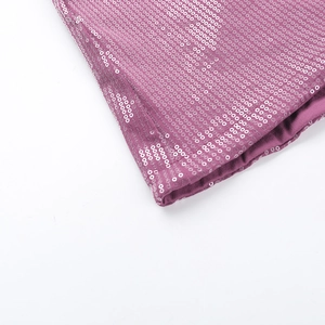 Close-up of shimmering rose pink sequins and detailed stitching on a mini dress
