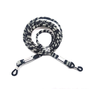 Close-up of black and white woven eyewear strap with silver metal sleeves and rubber loops