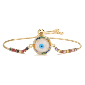 Detailed shot of gold evil eye bracelet with colorful crystals and adjustable slider
