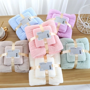 Detailed view of assorted coral fleece bath towel sets in various soft pastel colors