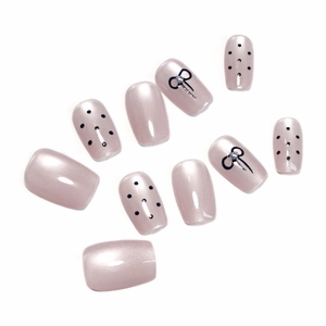 Handmade pearl pink press-on nails with black polka dots and 3D ribbon details