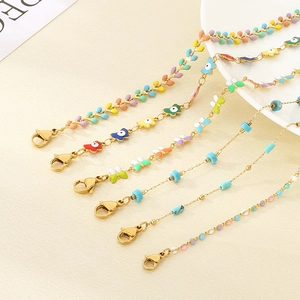 Detail of bohemian gold chains featuring colorful butterfly charms and beaded accents