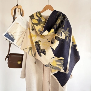Close-up of magnolia floral cashmere scarf with elegant fringe detail on hanger