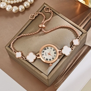 Detailed macro of rose gold watch dial with Roman numerals and clover charms