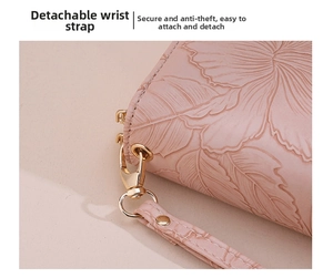 Detail of pink long wallet showing embossed leaf pattern and removable wrist strap