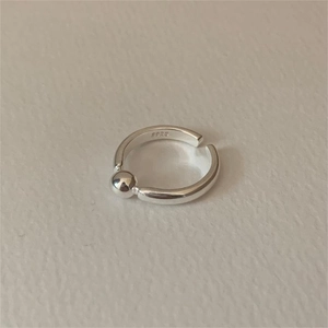 Minimalist 925 sterling silver open ring with polished metal bead on textured surface