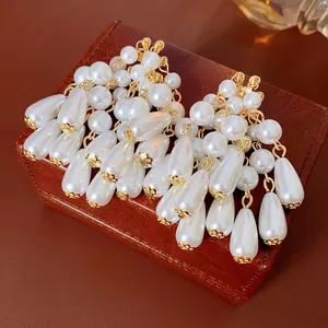 Elegant French style drop pearl tassel earrings with gold-tone accents on a leather box