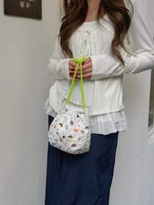 Detailed view of white quilted cartoon drawstring storage bag with cute animal patterns