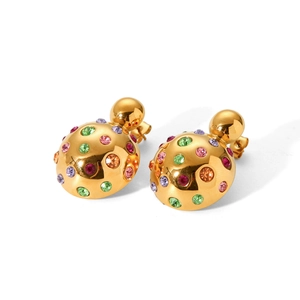 Macro detail of gold earrings featuring colorful rhinestones and a pearl-like double sphere