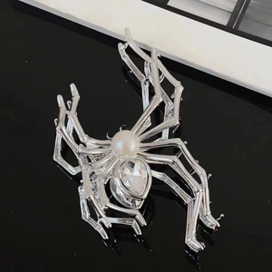 Macro detail of silver spider hair claw with white pearl and large crystal teardrop