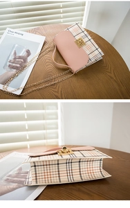 Close-up of pink and plaid crossbody bag with gold chain strap and turn-lock closure