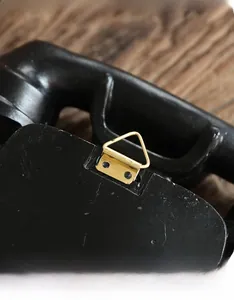Detail of a vintage wall telephone decor featuring a secure golden alloy triangular hook
