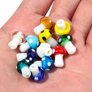 Close-up of handmade colorful glass mushroom beads with white polka dots for DIY jewelry