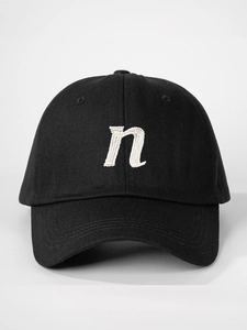 Close-up of premium white embroidered letter n on black cotton baseball cap